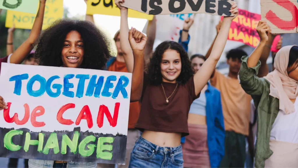 Young campaigners marching with hand-painted placards reading Together we can change
